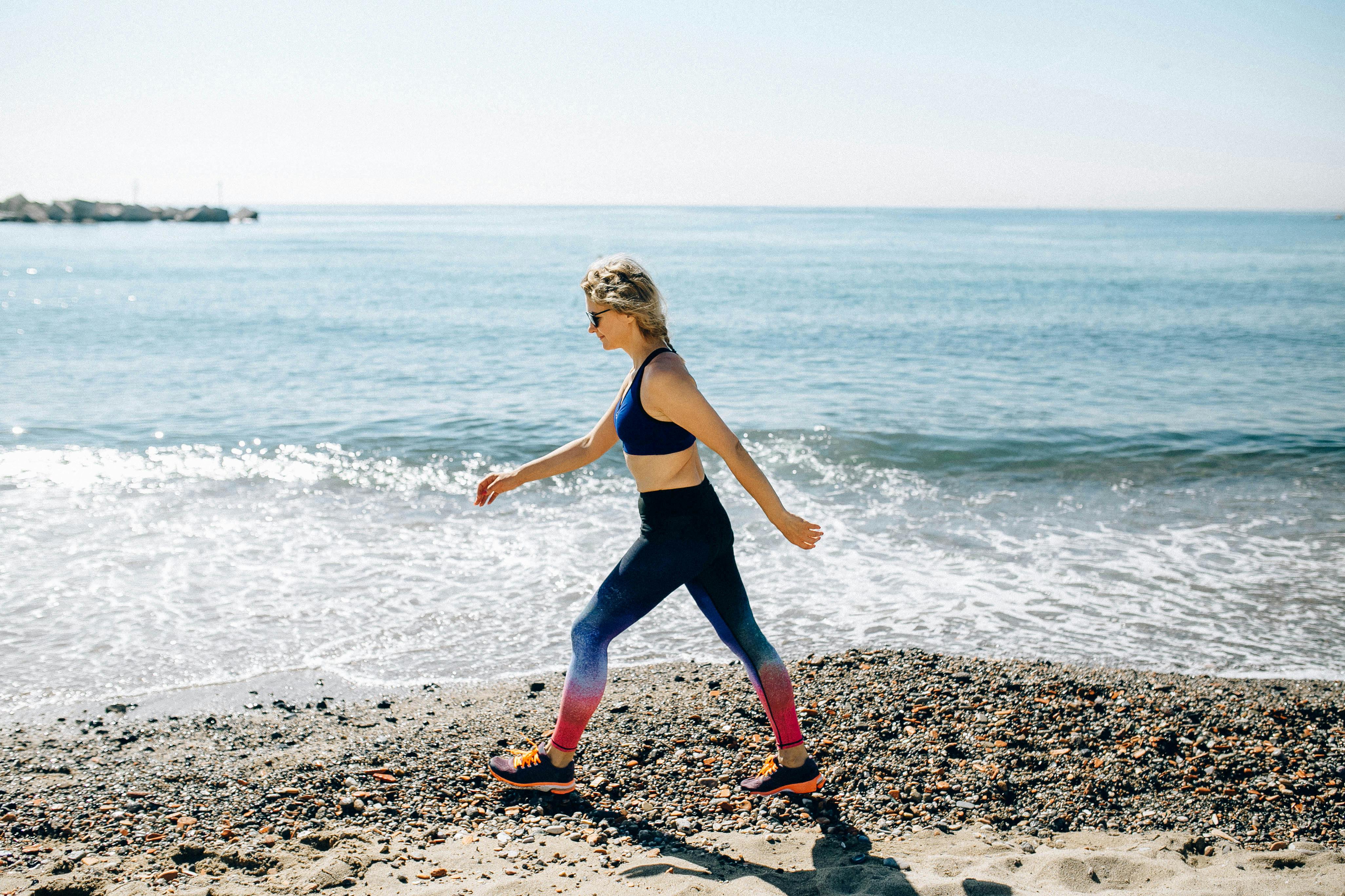 Woman walking forward on a sunlit beach