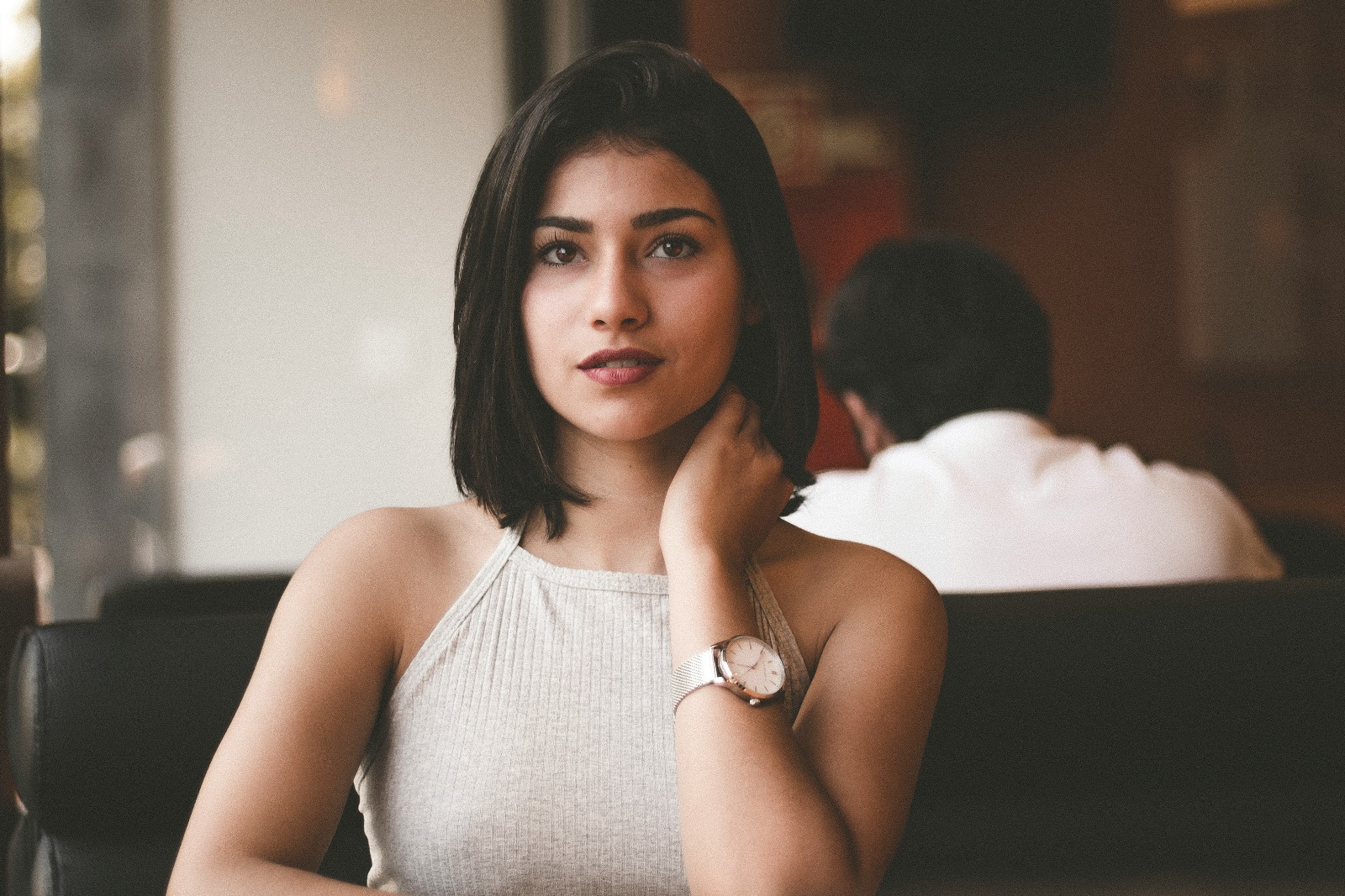 A thoughtful woman sits quietly by herself at a restaurant.