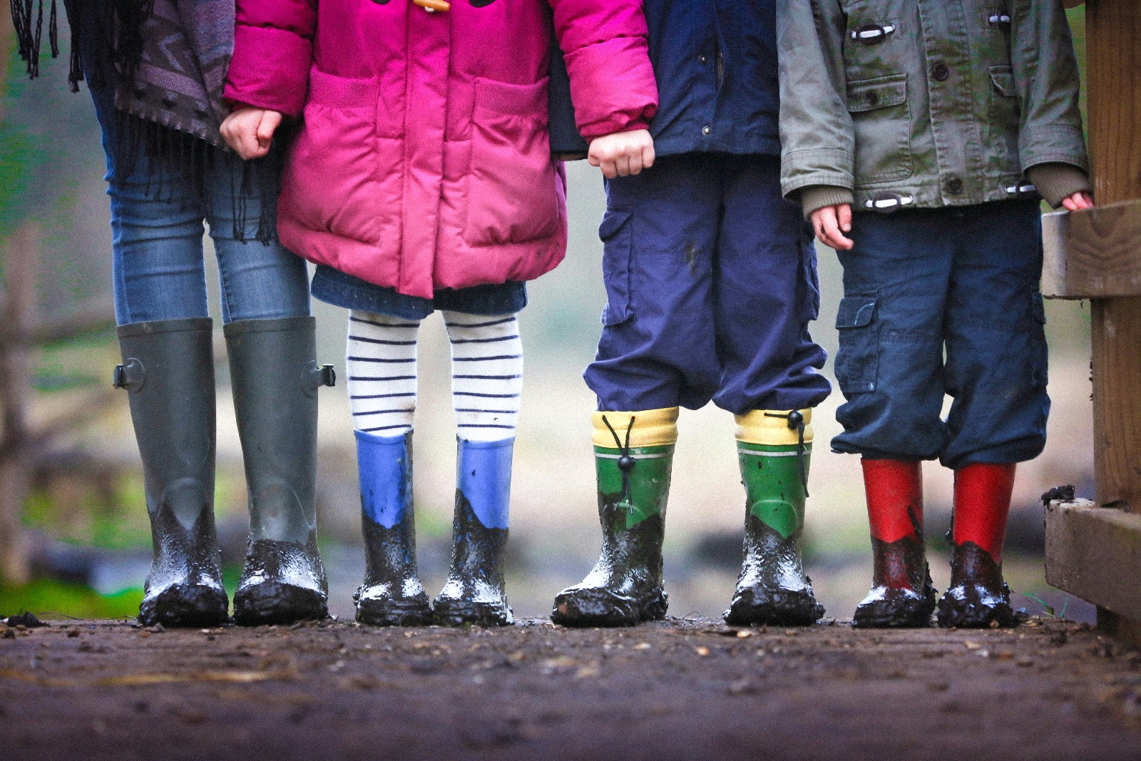 kids standing together with boots on and colorful clothes.